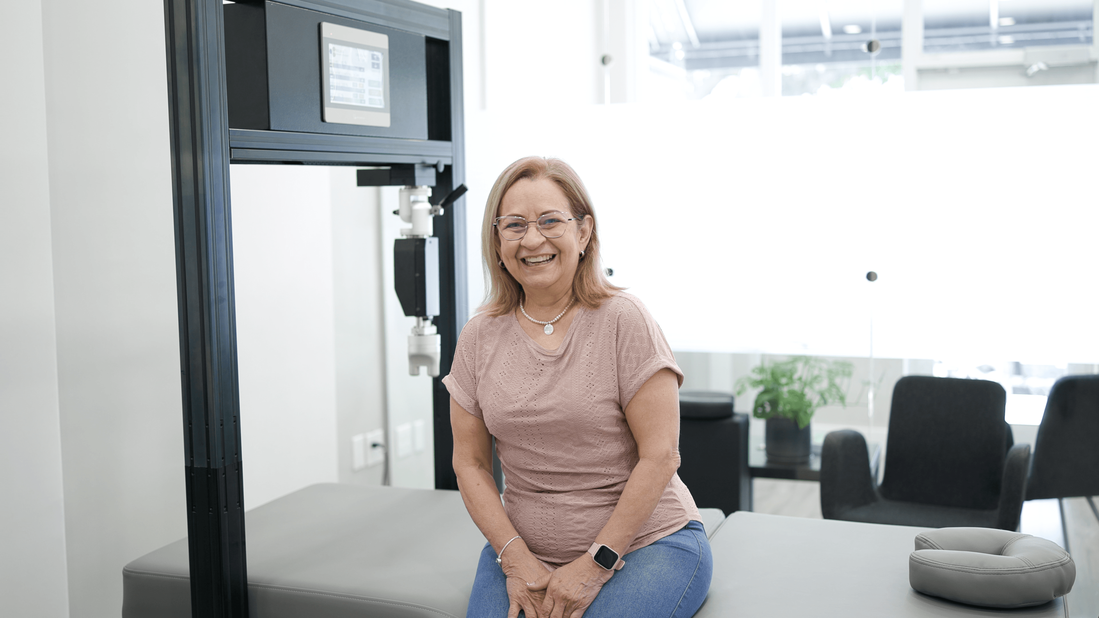 Smiling client at TheraMax with robotic therapy equipment